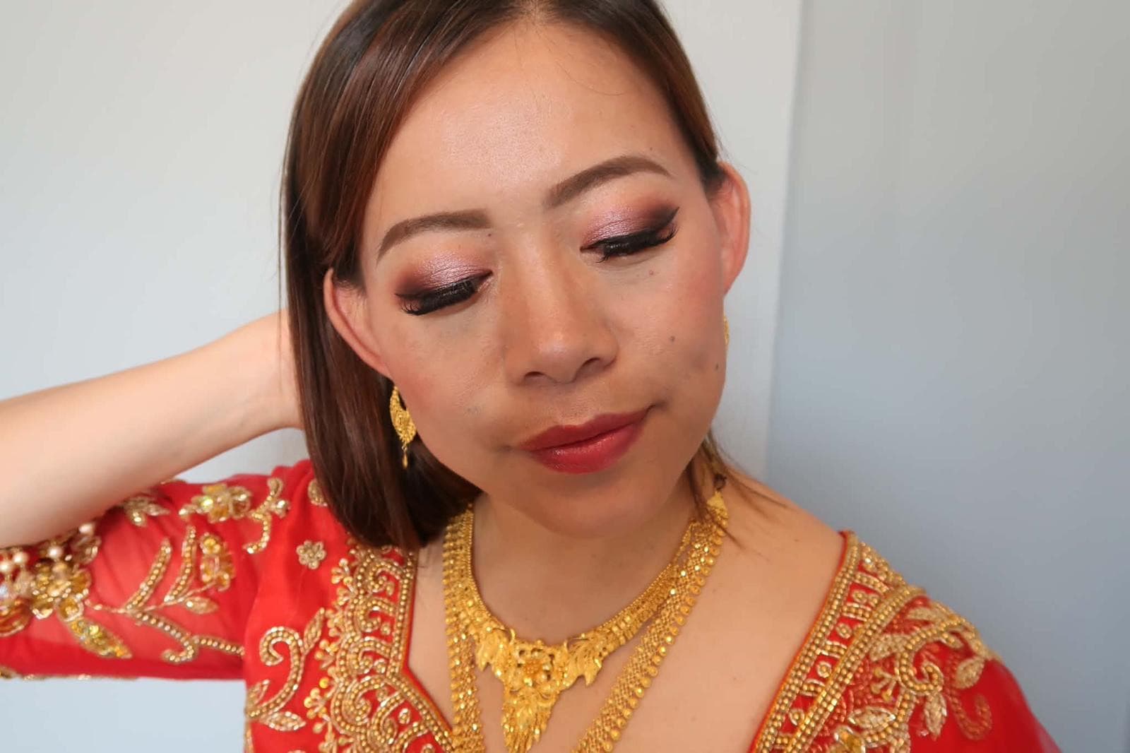 Bride in red and gold with bridal makeup by Bingussi Beautique